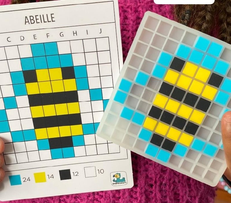 Grille translucide avec pixel art abeille terminé, comparé à la carte modèle